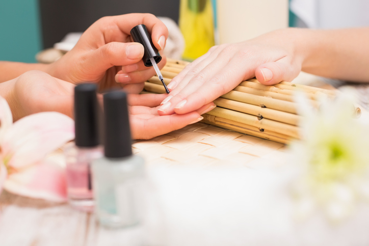 Nail technician giving customer a manicure at the beauty salon